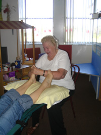 Mary Gilhholy giving a reflexology treatment to Tina